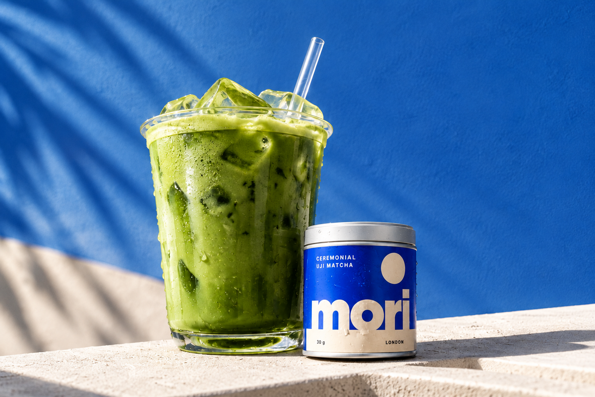 Iced matcha latte beside a Mori matcha tin