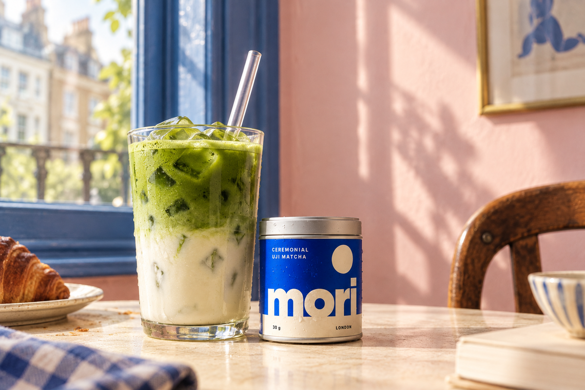 Layered iced matcha and a Mori tin in a sunlit London café
